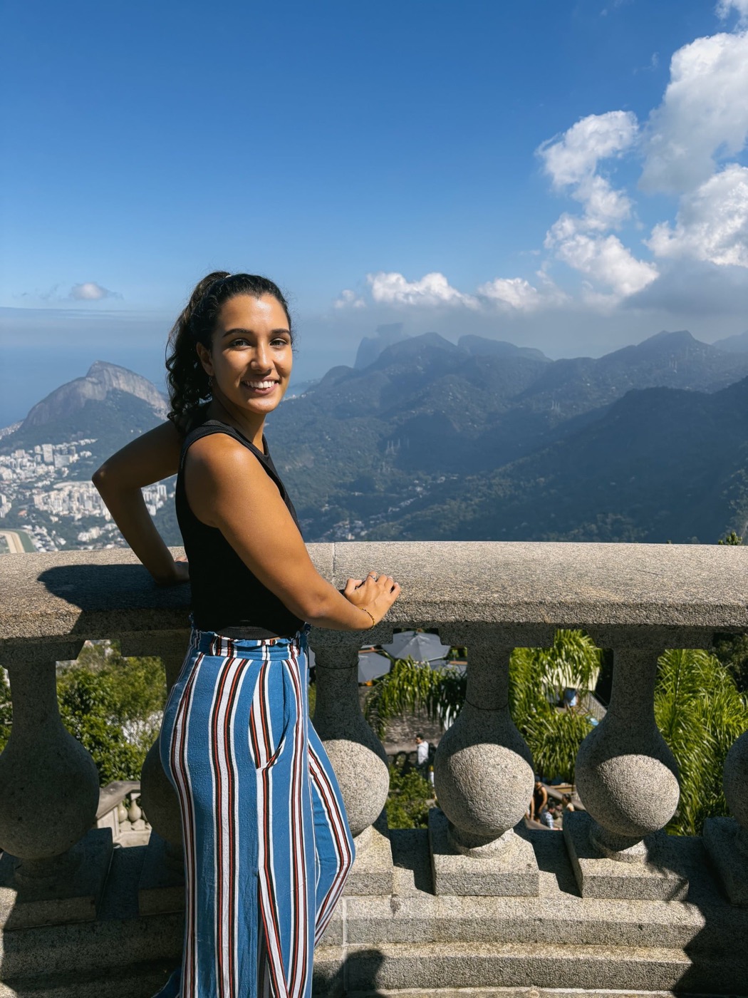 Sofia smiling in Rio de Janeiro with the mountains of Rio behind her